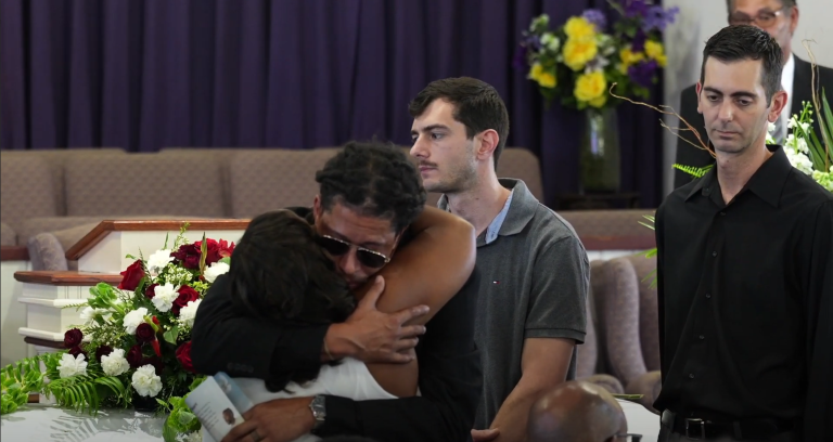 Two People hugging at a funeral